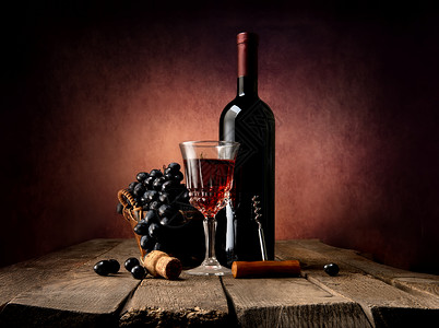 在篮子里的葡萄和在木制桌上的葡萄酒图片