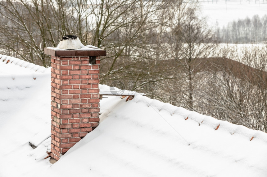 冬季和节特定红烟囱和屋顶覆盖着雪图片