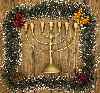 Hanukkah是犹太新年在木制背景上挂着圣诞装饰品的蜡烛图片
