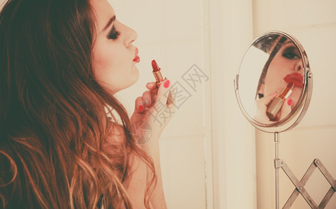 年轻女孩化妆漂亮在浴室化妆女人注意看着镜子亲吻回顾风格图片