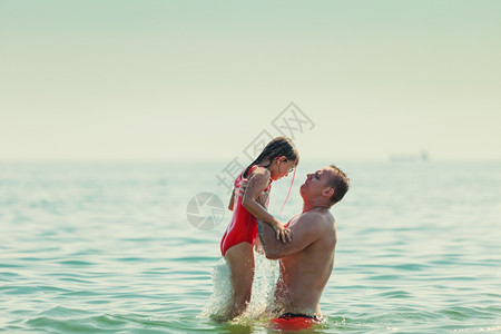 小孩和男人在海水中洗澡暑假放松图片