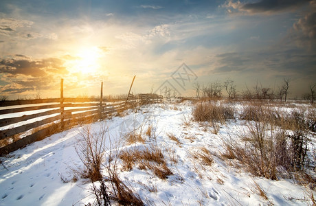 日落时冬田的木栅栏图片