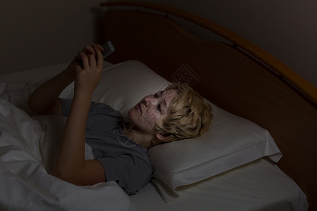 青少年女孩在床上使用手机夜间技术而不是睡觉图片
