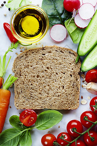整片小麦面包和健康有机蔬菜用于制作三明治健康饮食或烹饪概念图片