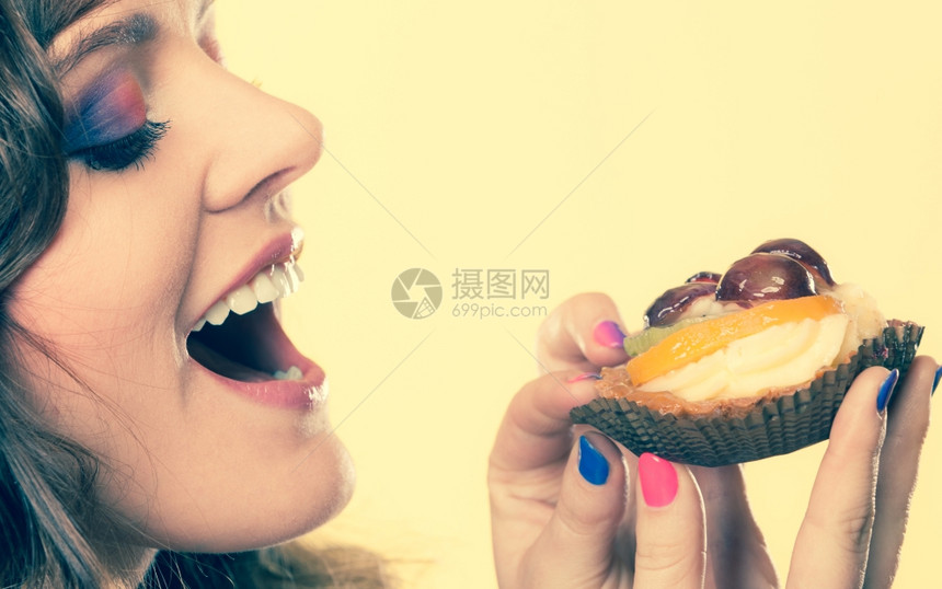 甜和快乐的概念近身可爱的卷发美女吃水果蛋糕图片