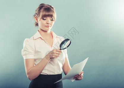 商业妇女使用放大镜检查信封过滤器照片图片