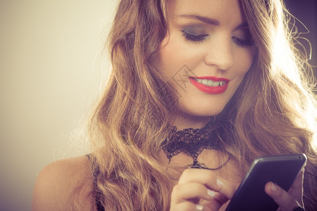 有智能手机的感女人沟通和联系想法带着手机智能短信的感有魅力笑女人室内图片