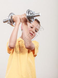运动男孩与哑铃一起锻炼图片