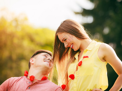 年轻情侣戴着红心项链在公园约会图片