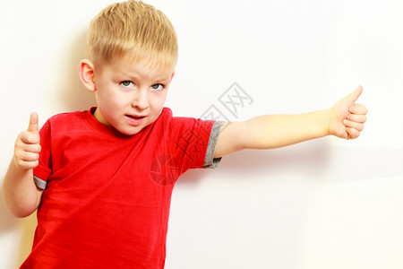 金发男孩竖起拇指举起成功的手势图片