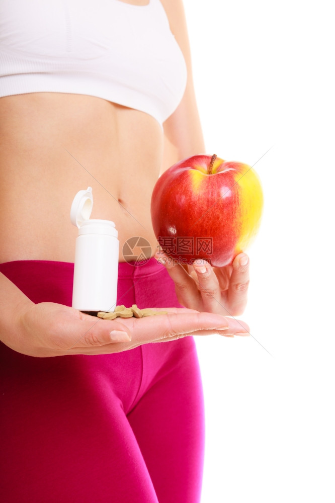 持有药丸和苹果的年轻女子天然合成维生素的选择保健康的生活方式营养概念孤立于白种背景图片