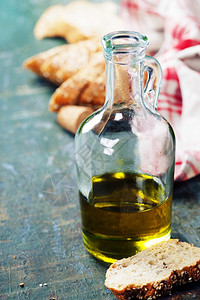 意大利面包用橄榄油在木制生锈的桌子上浇地背景