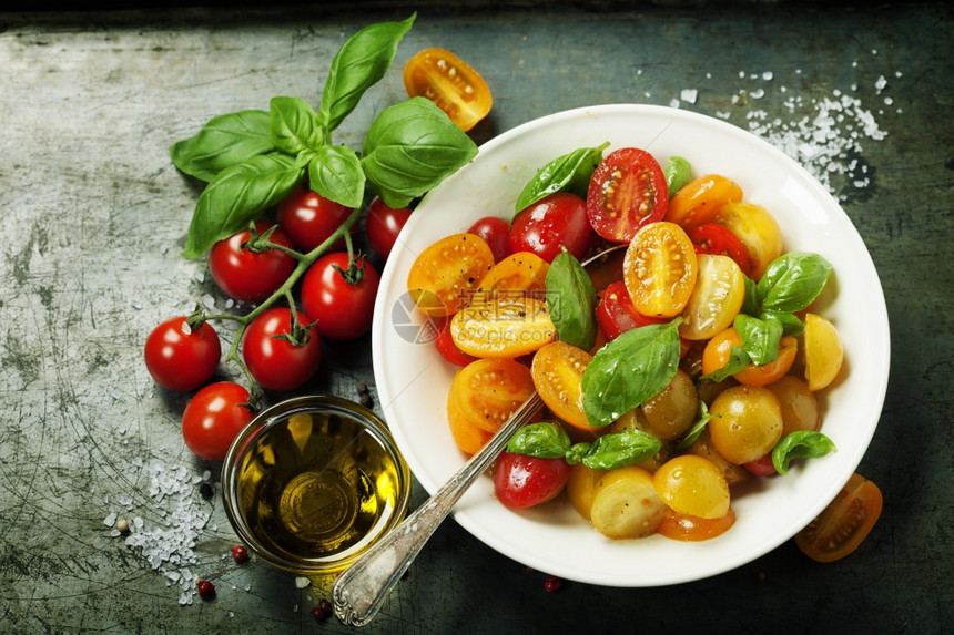 新鲜的西红柿有巴尔树叶在一个碗中以古老背景图片
