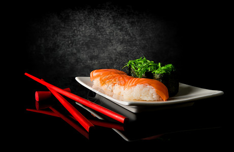 黑背景的寿司和筷子图片