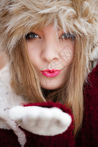 冬时装穿着冬装服的特紧女穿着时装的冬服毛帽吹着户外亲吻肖像图片
