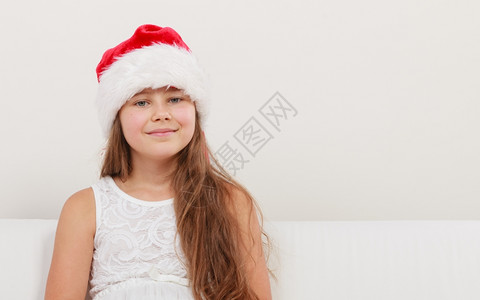 穿着红圣达克萨斯帽子和白裙的可爱小女孩背景图片