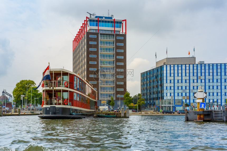 荷兰阿姆斯特丹运河船只和现代建筑的城市景象图片