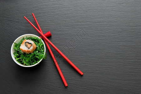 寿司卷和海草贴在一张桌子上图片