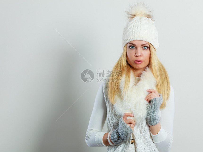 穿着冬衣的年轻金发女郎穿着时装的冬季服白毛围巾羊帽制片厂拍摄图片