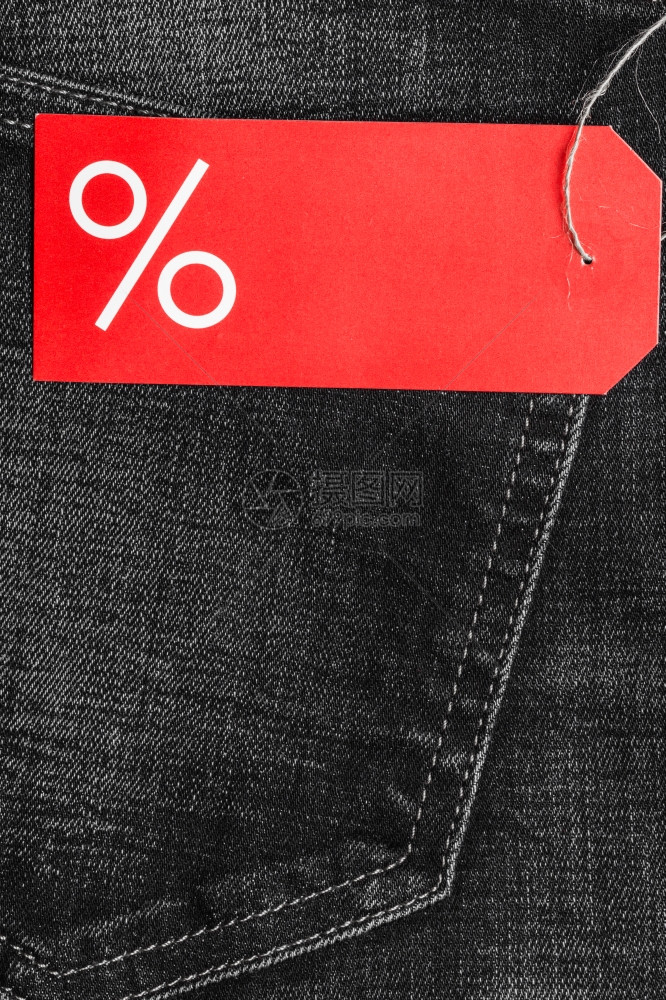 购物和销售概念关闭红色标签在黑牛仔裤口袋服棉材背景上加百分数符号和复制空间图片