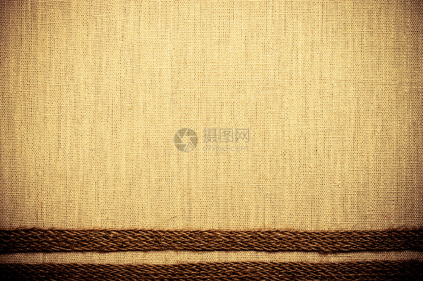 天然亚麻布背景的明织纺品材料上黄麻袋带图片