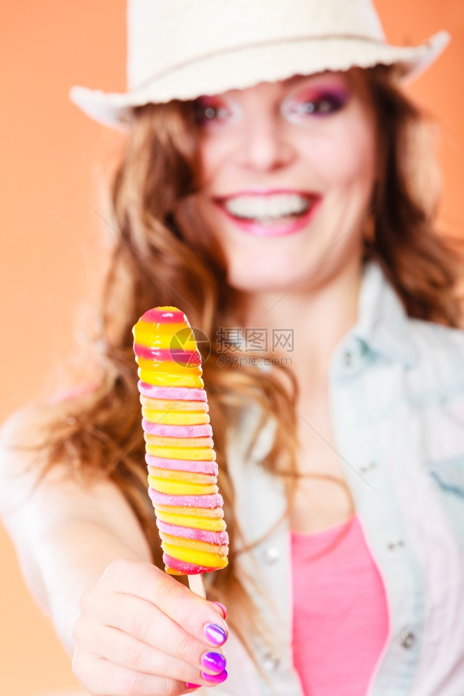 夏天假期快乐的概念笑快乐女人穿着草帽吃冰淇淋橙色背景图片
