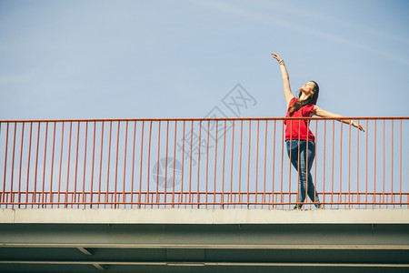 长发少女在城市桥上跳舞夏天的生活方式很怪异特伦迪运动少年玩得开心图片