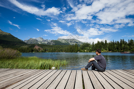 坐在高山湖岸上的人高清图片