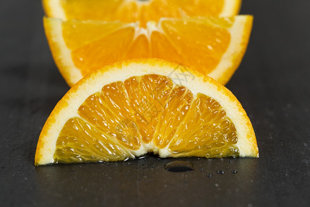 在天然石块上贴近一小片多汁的橙子水果有选择地关注水果的前部图片