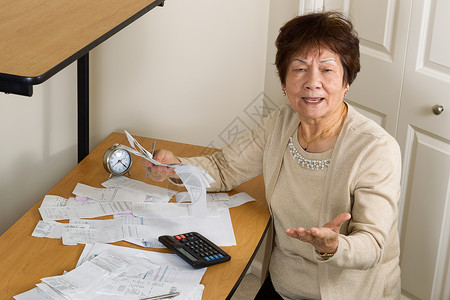 年长妇女在写财政帐单时表示极度愤怒债务概念图片