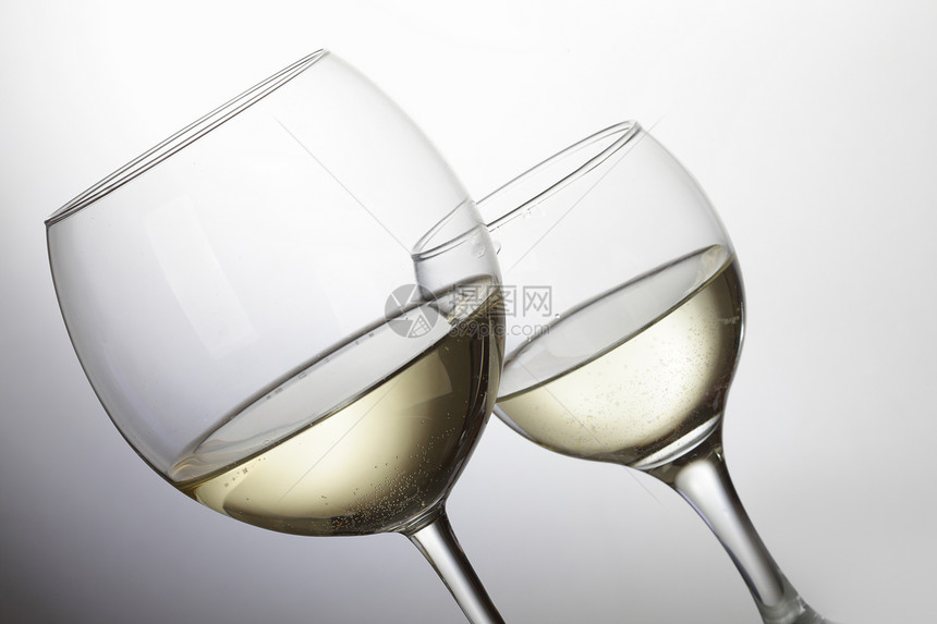 两杯白葡萄酒放在浅灰色背景上图片