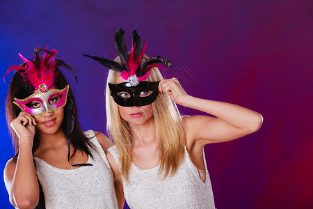 羽毛面具节日人和庆典概念两位女混血儿和caucasian背景
