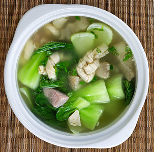 亚洲汤的高角度观包括竹垫上的猪肉子和色蔬菜图片