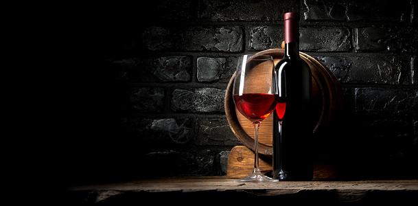 在旧黑砖背景上的红葡萄酒图片