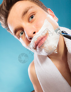 年轻人用奶油泡沫刮剃刀图片
