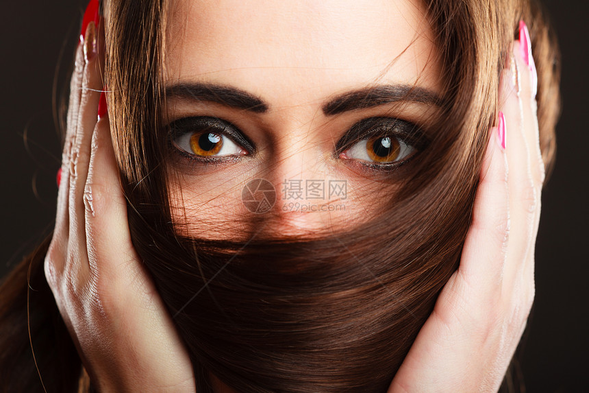 近女脸面罩着长棕色头发图片
