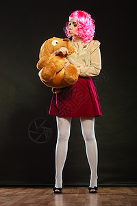 站立米奇玩偶象小孩一样的年轻女穿着像木偶娃和大狗玩具背景
