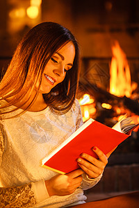 女人在壁炉里看书冬天家放松年轻女孩暖和放松冬天在家图片
