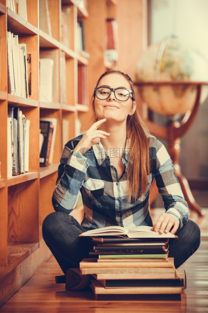 教育学校概念聪明的女学生毛发马尾小女孩眼镜坐在有书本的大学图馆地板上图片