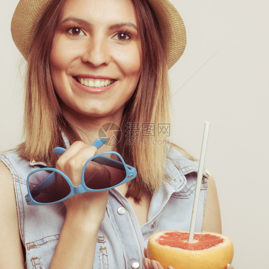 戴帽子的快乐女人拿着太阳眼镜和葡萄汁戴着草帽的快乐女游客拿着太阳眼镜和葡萄水果健康饮食品暑假概念图片