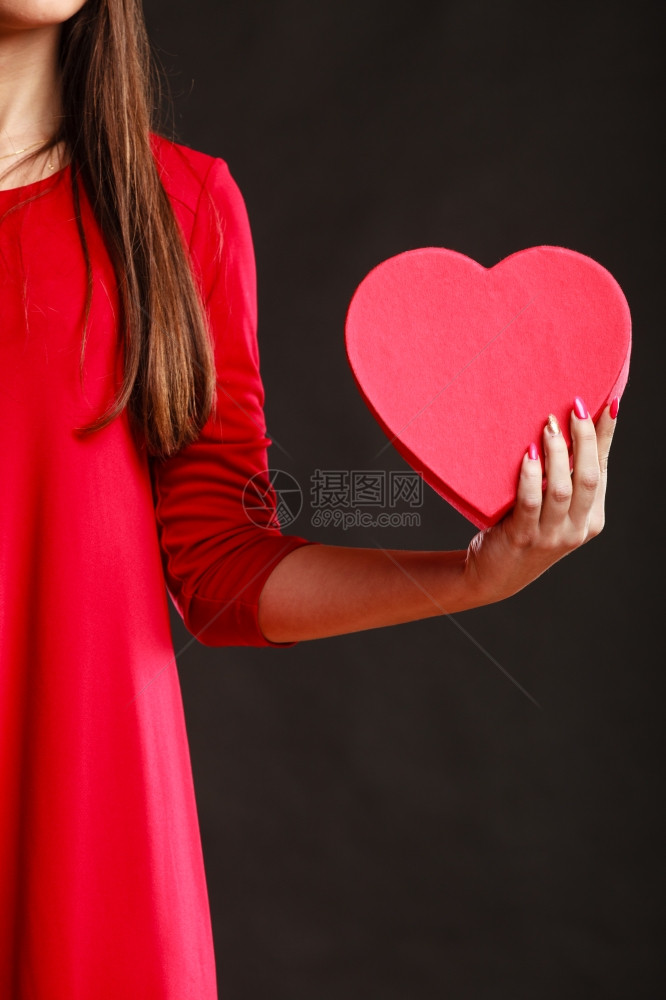 情人节爱浪漫概念穿红礼服的女人拿着心形礼物盒图片