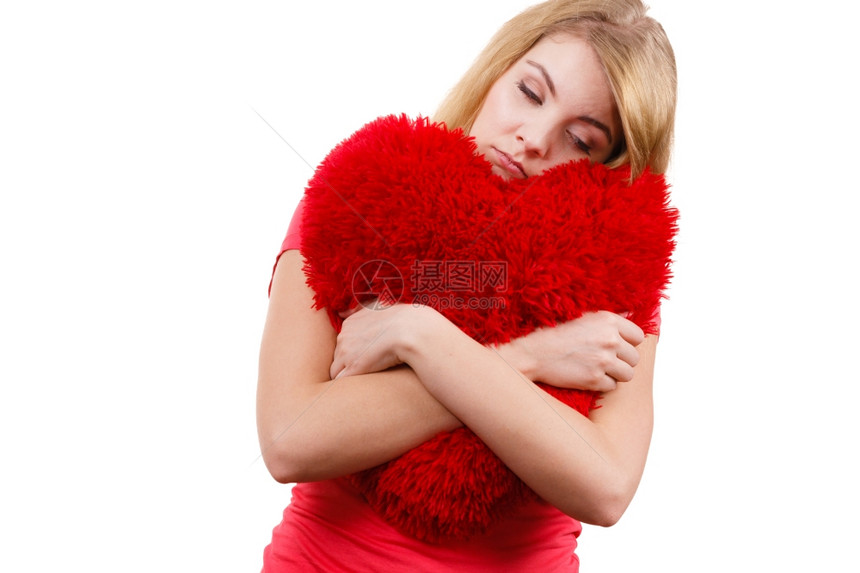 怀着红色心爱象征的悲伤女孩拥抱着红色心的悲伤不快乐女孩拥抱着红心的悲伤女孩怀着白色的大枕头工作室心碎的年轻女图片