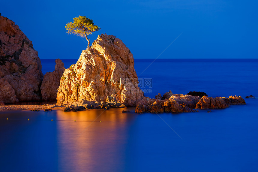 夜海在西班牙加泰罗尼亚州科斯塔布拉瓦岛GranPlatja海滩和托萨德马岛TossadeMar的BadiaTossa湾的浅地岩石图片