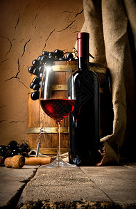 酒和葡萄在地窖的粘土墙附近图片