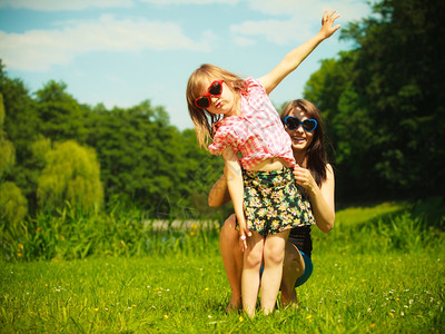 暑假小女孩儿在草地上或公园里和母亲玩耍图片