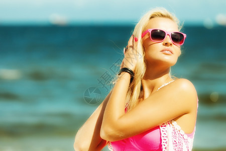 度假旅行和自由概念美丽的金发女孩躺在沙滩上肖像背景图片