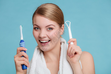漂亮的年轻女孩有电刷和舌头清洁剂快乐的女士清洁她口腔关心牙科健康图片