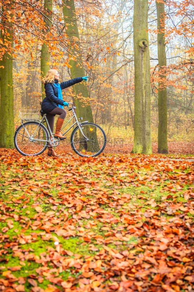 在森林公园骑自行车的妇女手指远方图片