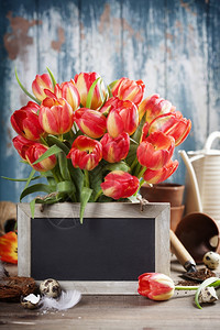 美丽的红色郁金花束东方鸡蛋和木制桌上的园具春天东方或园艺概念图片