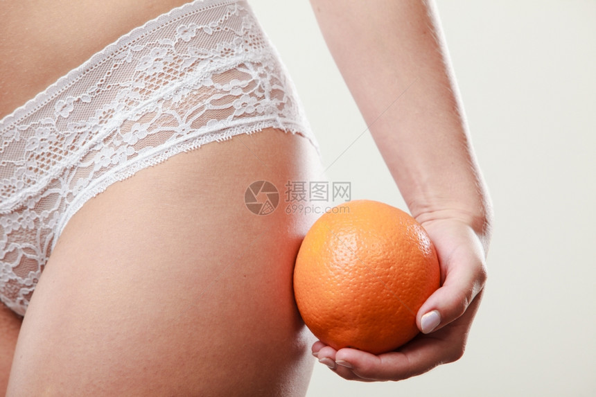 女孩紧握着橙色没有纤维素部分身材瘦的女孩子紧握着橙色在臀部旁边穿着白拉西内衣的妇女饮食方面图片